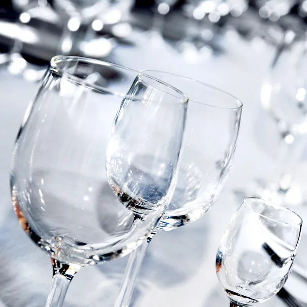 Три скляні келихи на білому столі — стокове фото