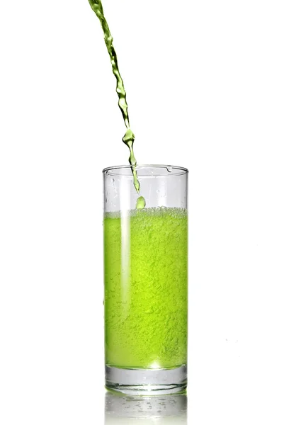 Зеленый сок наливается в стекло — стоковое фото