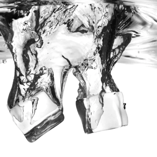 Кубики льоду впали у воду з бризкою — стокове фото
