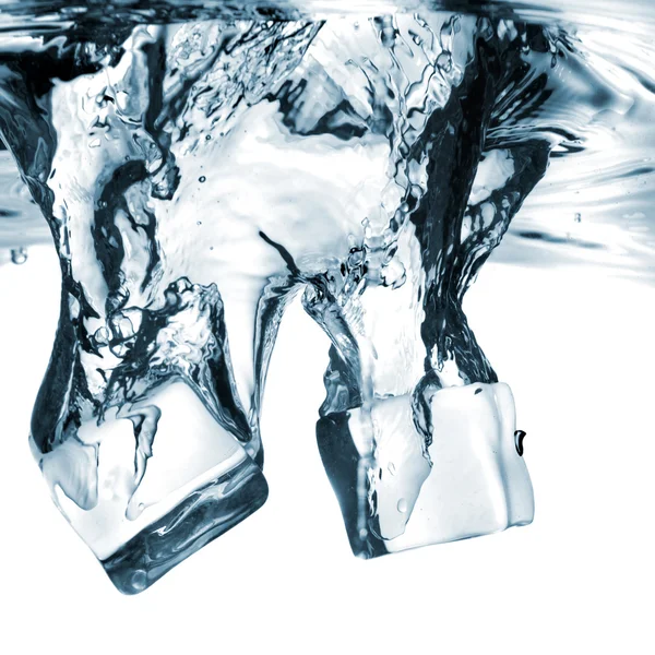 Cubos de gelo caíram na água com respingo — Fotografia de Stock