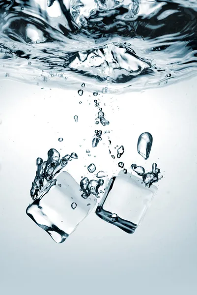 Ijsblokjes gedaald in water met splash — Stockfoto
