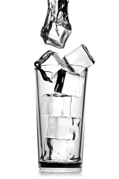 Ледяные кубики падают в стекло с пузырьками — стоковое фото