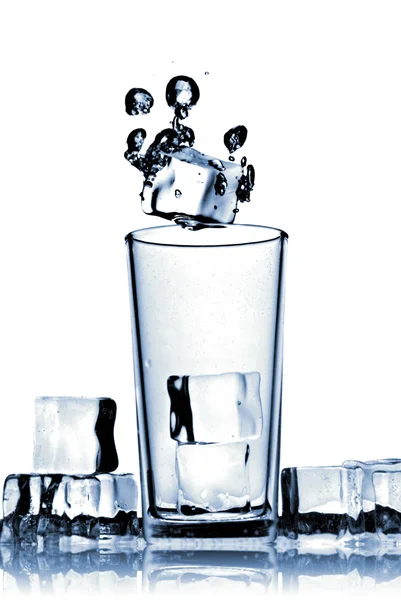 Isbitar föll i glas med bubblor — Stockfoto