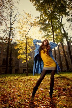 Woman in blue jaket in autumn park clipart