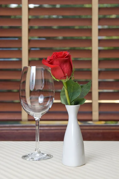 Vinho e rosa sobre a mesa — Fotografia de Stock