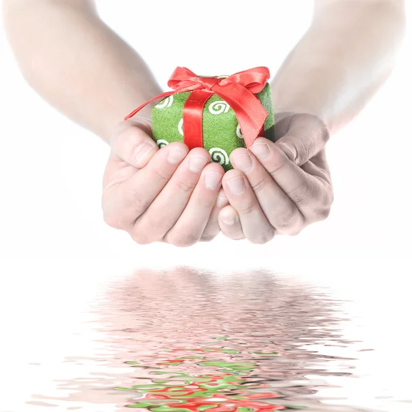 Hands holding gift with reflection — Stock Photo, Image
