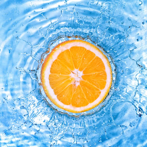 Свежий апельсин упал в воду с пузырьками — стоковое фото