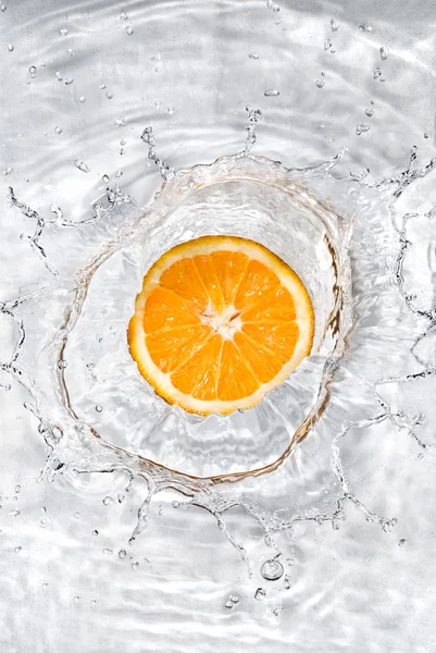 Свіжий апельсин впав у воду з бульбашками — стокове фото