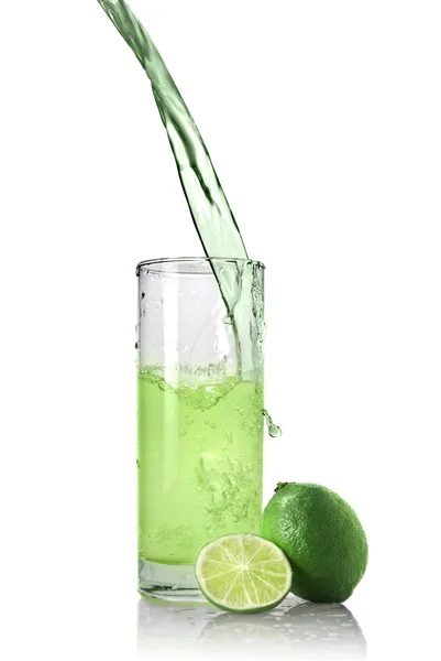Succo verde con versamento di lime nel bicchiere — Foto Stock