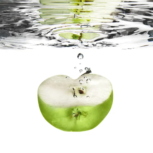 Зеленое яблоко упало в воду с пузырьками — стоковое фото
