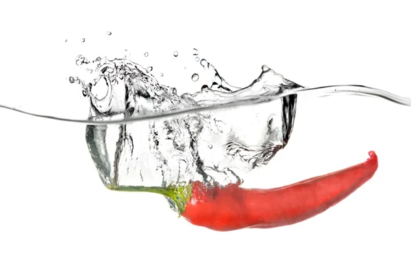 Red pepper dropped into water with splash — Stock Photo, Image