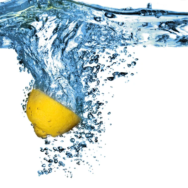 Свежий лимон капал в воду с пузырьками — стоковое фото