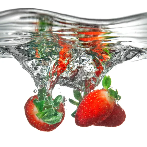 Fresh strawberry dropped into water with splash — Stock Photo, Image