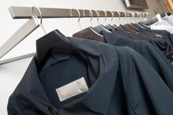 Kleidungsstücke auf Regalen im Geschäft — Stockfoto