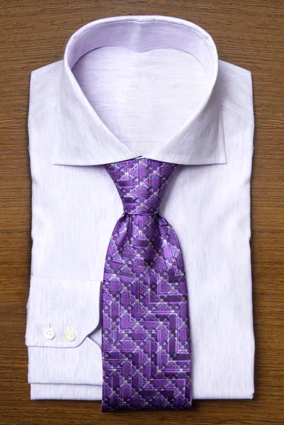 Tričko s fialovou kravatou na dřevěné police — Stock fotografie