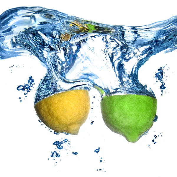 Citroen en limoen gedaald in water met bubbels geïsoleerd op wit — Stockfoto