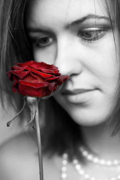Donna che guarda la rosa rossa — Foto Stock