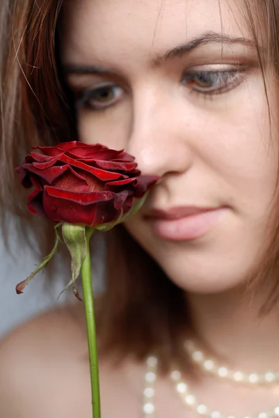 Femme regardant rose rouge — Photo