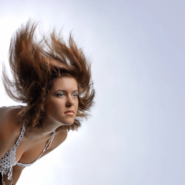 Jovem mulher com cabelo em movimento — Fotografia de Stock