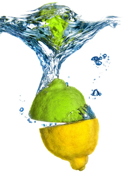 Citron och lime tappade i vatten med bubblor isolerad på vit — Stockfoto