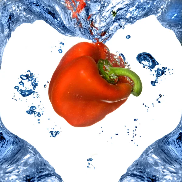 Rode paprika met vorm van hart van blauw water geïsoleerd op wit — Stockfoto