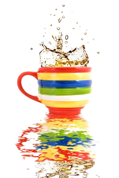 stock image Splash of tea in color cup with reflection