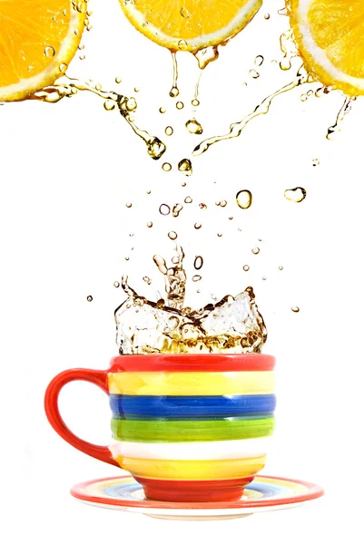 Três limões, xícara de cor e respingo de chá isolado em branco — Fotografia de Stock
