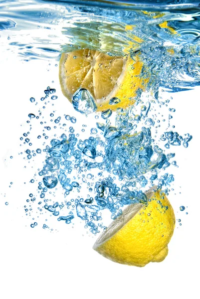 Limón fresco arrojado al agua con burbujas aisladas en blanco — Foto de Stock