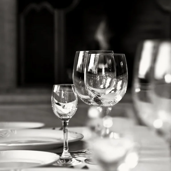 Μαύρο και άσπρο φωτογραφία από γυάλινα ποτήρια στο τραπέζι — Φωτογραφία Αρχείου
