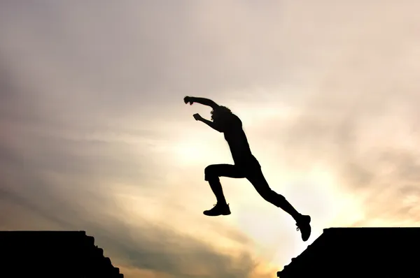Silhouette eines springenden Jungen gegen einen — Stockfoto
