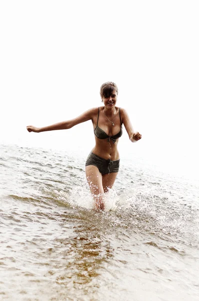 Счастливая девочка бежит в воде — стоковое фото