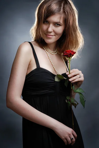Atrakcyjny, uśmiechnięta młoda kobieta z różą — Zdjęcie stockowe