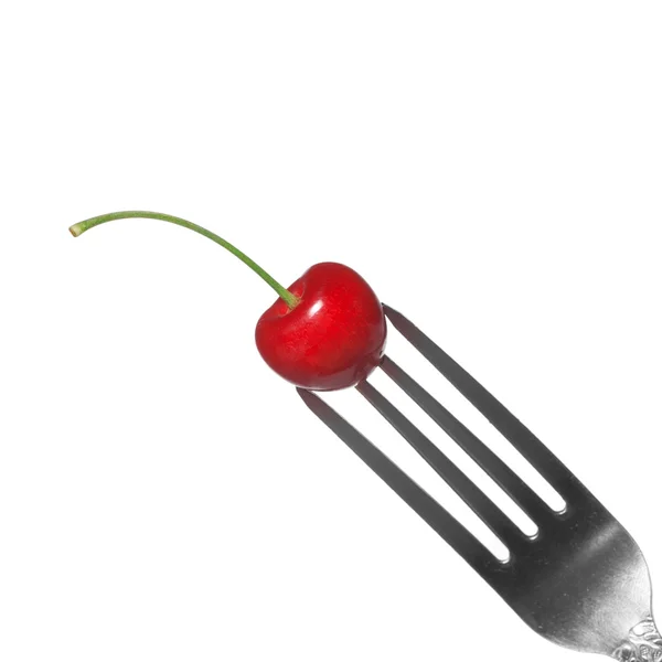 stock image Red cherry on fork isolated on white