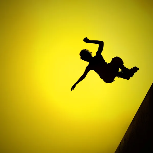 Silhouette eines Rollerjungen, der in die Luft springt — Stockfoto