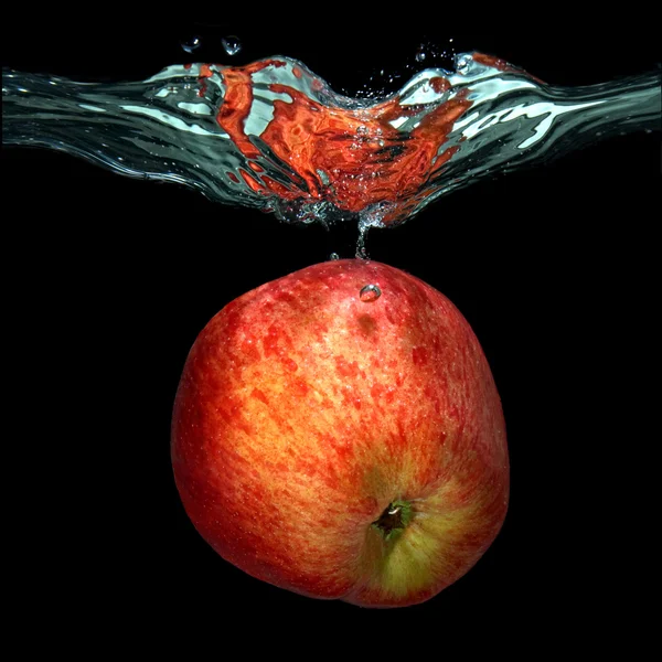 青苹果掉入水中与飞溅孤立在黑色 — 图库照片