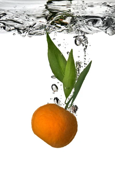 Tangerine gedaald in water met bubbels op wit — Stockfoto