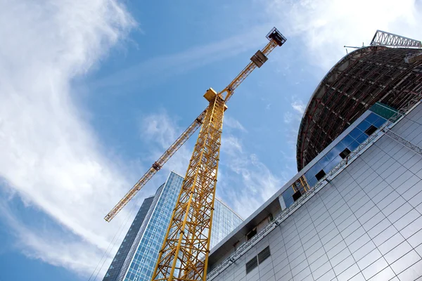 Edificio moderno en construcción contra el cielo azul — Foto de Stock