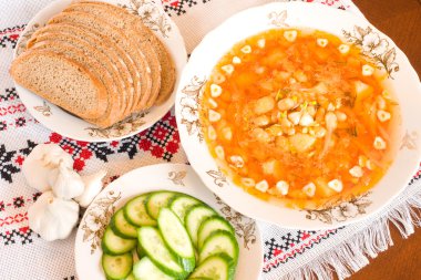 Borsch, siyah ekmek ve dilimlenmiş salatalık