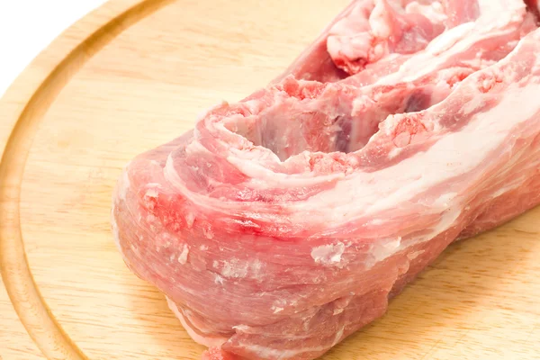 Rohes Schweinefleisch auf runder Hartfaserplatte — Stockfoto