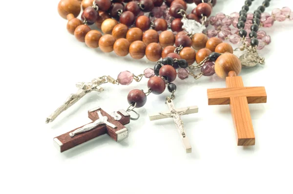 Rosary beads over white with focus on crosses — Stock Photo, Image