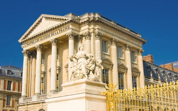 Статуя і палац фасадом з колонами у Версалі — стокове фото