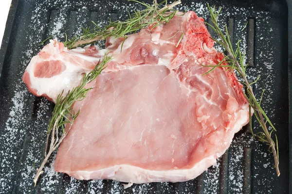 Сковородка с сырой свининой — стоковое фото