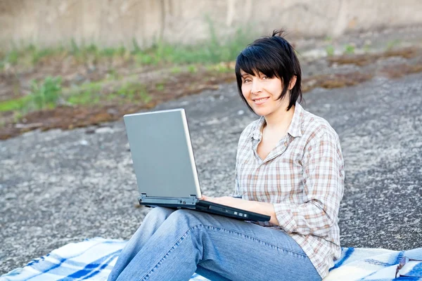 Frau arbeitet draußen am Laptop — Stockfoto