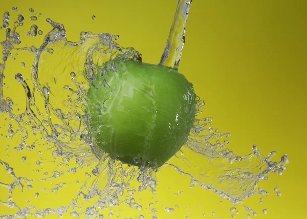 Green apple on yellow background — Stock Photo, Image