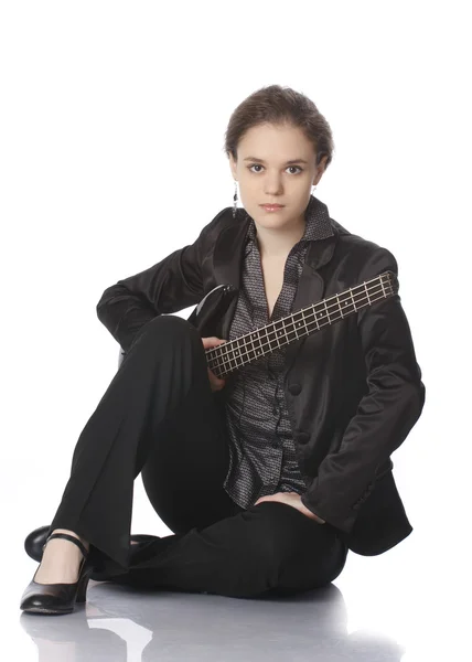 Dziewczyna siedzi z gitara bas czarny — Zdjęcie stockowe
