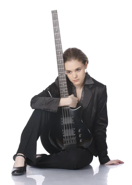 ベースギターを持つ着席の少女 ストックフォト