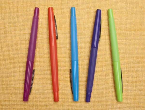 Живые ручки на жёлтом фоне — стоковое фото