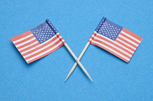 Американские флаги на голубом — стоковое фото