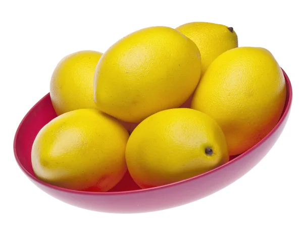 Levendige gele citroenen in een roze kom — Stockfoto