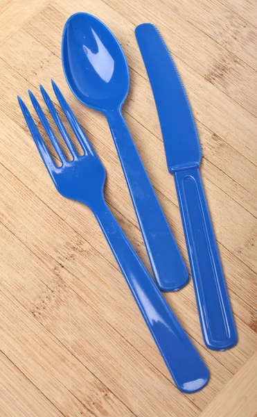 Синій пластиковий срібний посуд на дерев'яному тлі — стокове фото